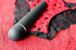 black dildo on top of a black and red bikini